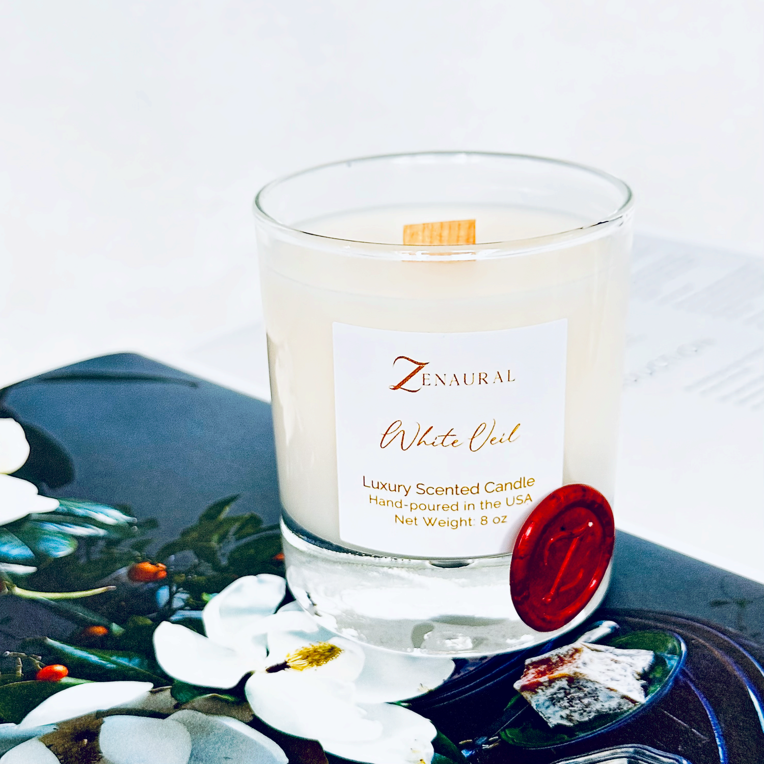 White Veil — clear glass candle with white Zenaural label and wooden wick, red wax seal on a floral plate, Veloria Collection by Zenaura Studio.
