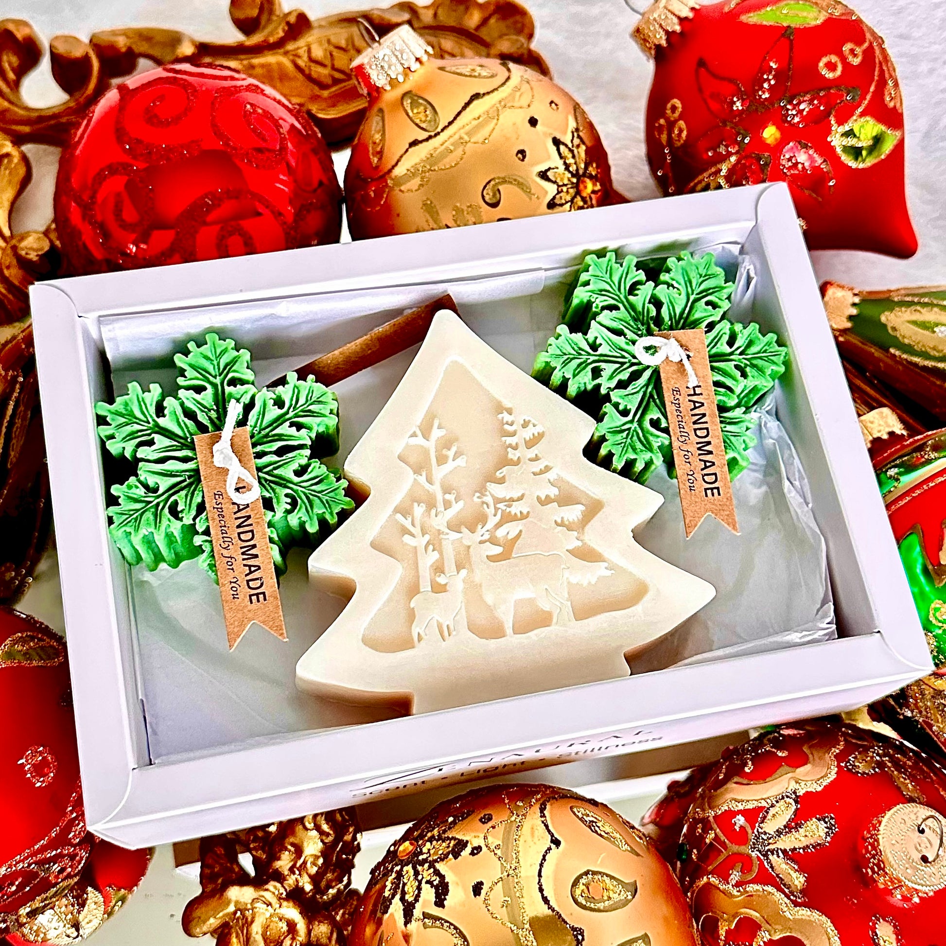 White Christmas tree candle with two green snowflake candles in a white gift box.