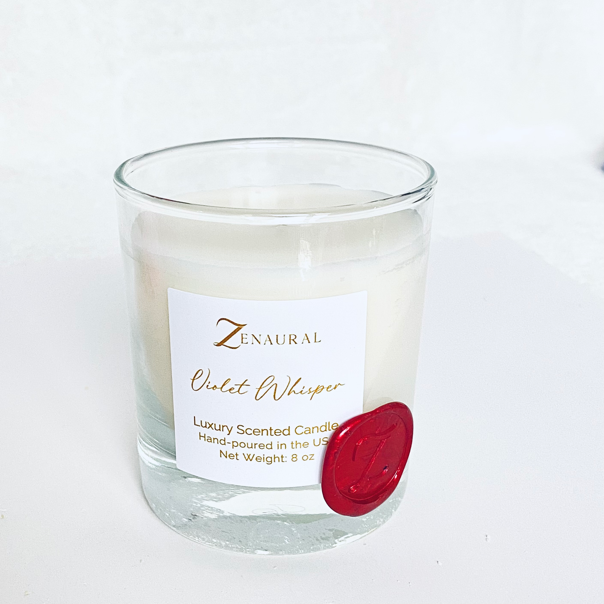 White Veil — clear glass candle with white Zenaural label and wooden wick, red wax seal on a floral plate, Veloria Collection by Zenaura Studio.